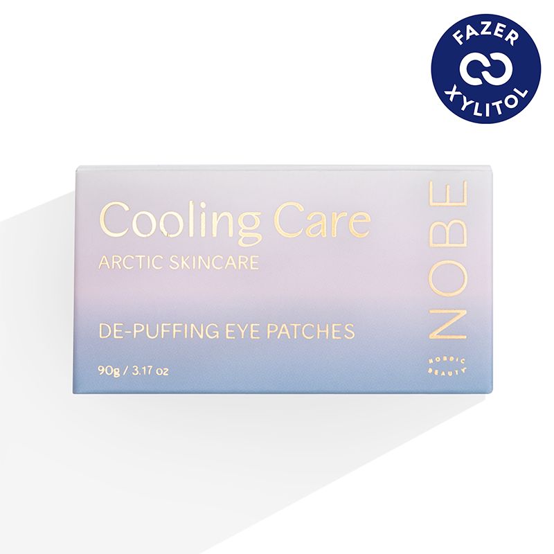 Rectangular box labeled Cooling Care Arctic Skincare De-Puffing Eye Patches with NOBE on the right. In the corner, a blue circular badge reads FAZER XYLITOL. The background is white with a soft shadow, highlighting the refreshing skincare design. Box has straight edges and matte finish; sans-serif text in various sizes; no people or hands present. Camera angle is front-facing studio shot.