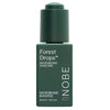A green bottle labeled Forest Drops Microbiome Booster by NOBE Nordic Beauty, 30 ml / 1.01 fl. oz., with a matching green cap, shown against a white background. Bottle has a cylindrical shape and matte finish; label uses sans-serif font in white contrasting with the dark green surface. No people or other items are present in the photo.