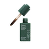 A green bottle labeled NOBE Forest Drops Microbiome Skincare stands upright on a white background, its open cap revealing a dropper filled with the dark liquid formula. The glass bottle has a cylindrical shape and matte finish. Label text is printed in simple, sans-serif font. The pipette dropper features a clear tube and black top. No people or hands are visible.