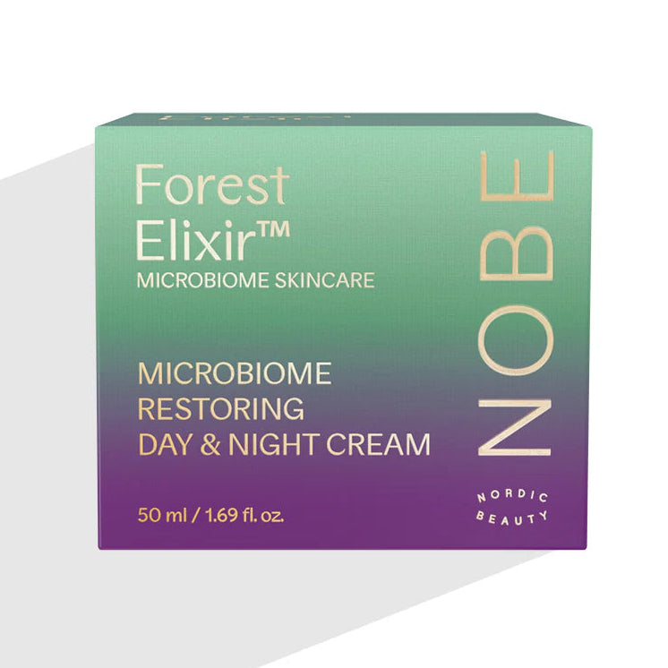 NOBE Forest Elixir® Microbiome Restoring Day & Night Cream: rasia NOBE Forest Elixir Microbiome Skincare Day & Night Cream -tuotetta, 50 ml, vihreä-violetti liukuvärillinen pakkaus kulta- ja valkoisella tekstillä, kaava auttaa palauttamaan ihon mikrobiomia; suorakulmainen kartonkirasia kiiltäväpinnalla, groteskikirjasin; ei ihmisiä tai käsiä näkyvissä, tuote kuvattu valkoista taustaa vasten suoraan edestä.