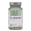 Natura Media B1-vitamiini 100 mg: läpinäkyvä sylinterimäinen muovipurkki, jonka läpi näkyy valkoisia kapseleita, sisältää 100 kapselia; korkki on sileä, heijastava hopeanvärinen kierrekorkki; etiketissä musta-kultainen teksti "B1-vitamiini TIAMIINI 100 mg" selkeällä groteskikirjasimella valkoisella pohjalla; tuote kuvattu valkoista taustaa vasten tasaisessa valaistuksessa.