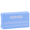 Nomai Superior Blades; sininen pakkaus tekstillä nomai SUPERIOR BLADES, sisältää 5 laadukasta ruostumattomasta teräksestä valmistettua partaterää; suorakaiteen muotoinen pakkaus tasaisella mattapinnalla ja terävin reunoin; lihavoitu valkoinen groteskiteksti, SUPERIOR BLADES isoin kirjaimin; terät osittain näkyvissä pienen ikkunan läpi pakkauksen etuosassa; vaalea tausta, ei ihmisiä tai käsiä; tavanomainen keskitetty tuotekuva.