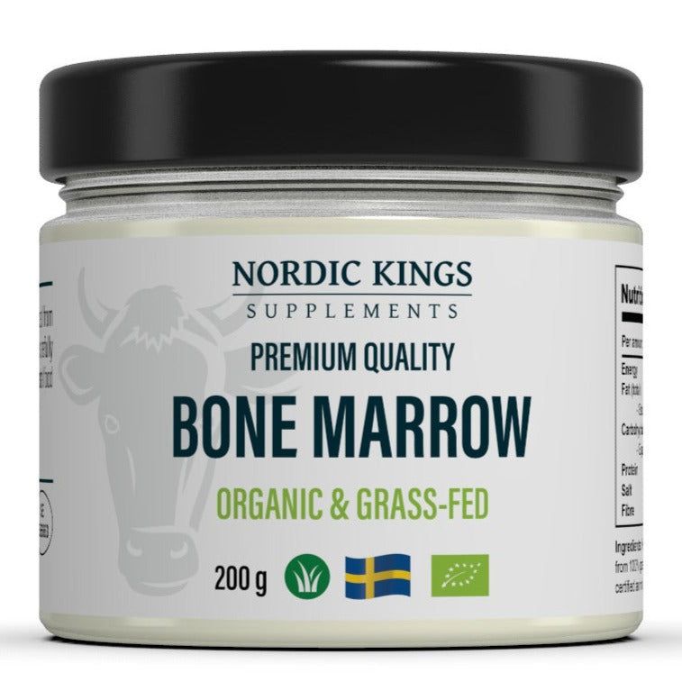 A jar labeled Nordic Kings Supplements Premium Quality Bone Marrow Organic & Grass-Fed, 200g, featuring icons for organic ingredients, grass-fed sourcing, the Swedish flag, and an illustration of a cow’s face. The jar is cylindrical with a dark-colored matte surface and a contrasting label. Label uses bold sans-serif typography in white and gold. Background is plain white; no people or hands are present. The shot is front-facing product photography with all text clearly legible.