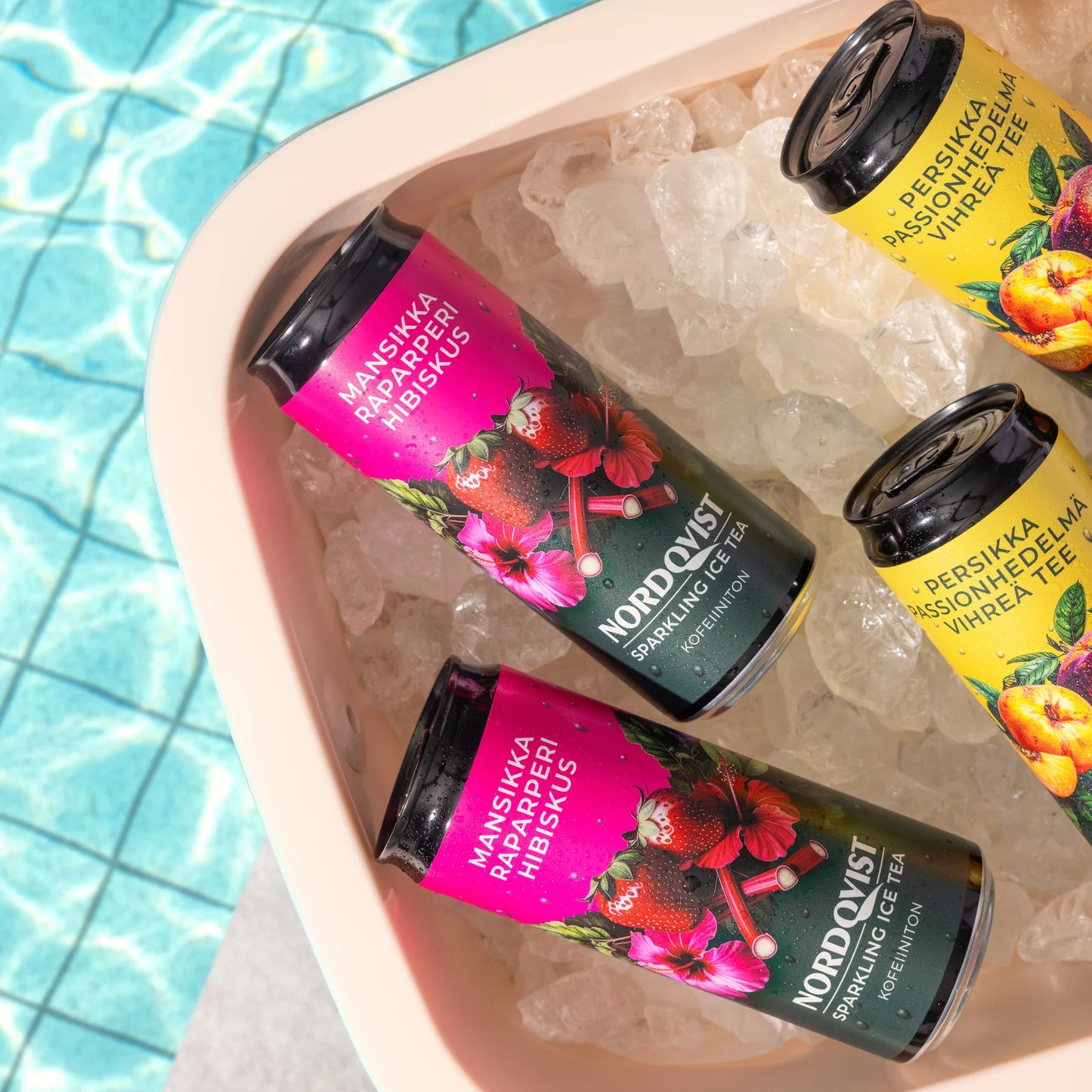 Nordqvist Sparkling Ice Tea Mansikka-Raparperi-Hibiskus: kolme eloisaa tölkkiä lepää valkoisessa jääastiassa uima-altaan vieressä taustalla kimalteleva sininen vesi; tölkit ovat sylinterimäisiä metallia kiiltäväpinnalla kolmessa eri värissä; jokaisessa suuri moderni groteskikirjasin tekstillä "Nordqvist"; ei ihmisiä tai toimintaa näkyvissä.