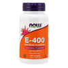 A white plastic bottle with a matte finish, cylindrical in shape. The label is orange and purple, includes a flower graphic, and uses bold sans-serif typography for the product name. Some smaller text is also present in white and orange. No people or hands are visible. The background is plain and neutral. A white bottle labeled NOW E-400 With Mixed Tocopherols, featuring antioxidant protection and containing 100 softgels. The label is orange and purple with a flower graphic, along with product details in