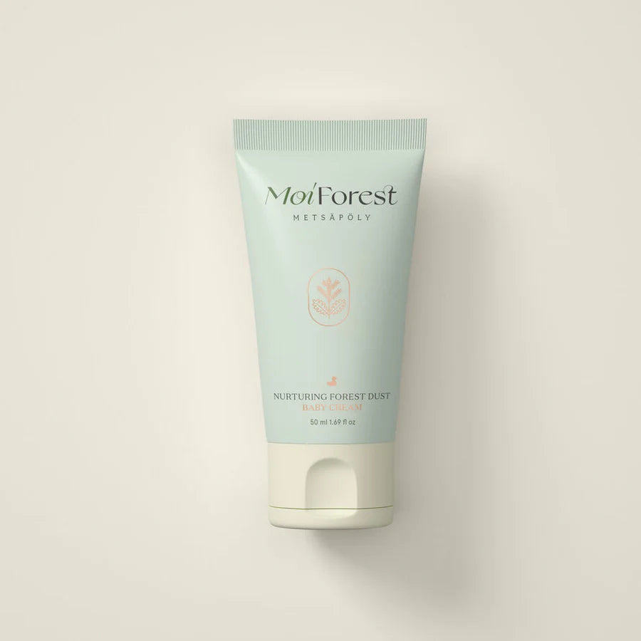 Moi Forest Forest Baby Box; vaaleanvihreä tuubi tekstillä Moi Forest METSÄPOLY Nurturing Forest Dust Baby Cream seisoo pystyssä yksinkertaista, luonnonvalkoista taustaa vasten; tuubi mattapintainen ja sileä lieriömäinen, litteä kansi; etikettiteksti painettu tummalla groteskikirjasimella; kuvassa ei muita esineitä kuin tuote ja tausta; hyvin valaistu, suoraan edestä kuvattu.