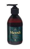 A dark pump bottle labeled Ole Hyvä Metsä Naava Käsipesu with a green and gold design, used for gentle hand wash. The bottle is cylindrical, made of opaque plastic with a matte finish. Label features sans-serif text with stylized elements in metallic gold and muted green ink. The product is photographed upright against a plain white background. No people or hands are present.