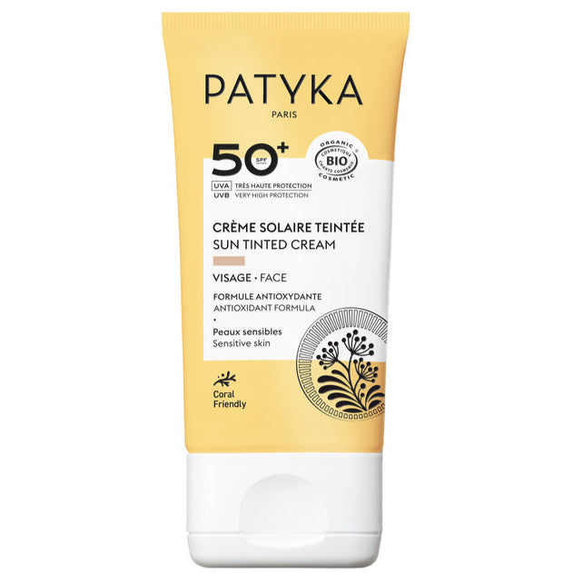 Patyka Tinted Face Sun Cream SPF50+; keltainen ja valkoinen tuubi Patyka Paris -sävytettyä aurinkovoidetta SPF 50+ herkälle iholle, sisältää antioksidanttikaavan ja laajan UVA/UVB-suojan, pakkauksessa koralleja säästävä merkintä; tuubi on pehmeää muovia mattapinnalla, pyöristetyt reunat ja litteä valkoinen korkki; etupuolen teksti on mustaa groteskia eri lihavuuksin; tausta valkoinen, ei ihmisiä tai rekvisiittaa näkyvissä.