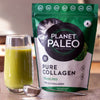 Planet Paleo Pure Collagen; Planet Paleo Pure Collagen -jauhepussi keittiötasolla, vieressä lasillinen vihreää kollageenijuomaa ja metallinen kauha; pussi mattamusta, suorakulmainen, valkoisin ja kultaisin lohkokirjaimin; teksti "Planet Paleo Pure Collagen" näkyvissä suuraakkosin; lasi lieriömäinen ja kirkas, kauha metallinen kiiltäväpintainen; vaalea ja sileä alusta; ei ihmisiä tai käsiä kuvassa.