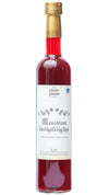 A clear glass bottle with red liquid and a gold cap. The surface is glossy. The label is white, featuring “Mausteinen käsityöläisglögi” in decorative lettering and small graphic elements. The bottle holds 0.5 liters. No people or hands are visible; background and setting are not specified in the image provided.