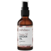 Puhdas+ Beauty Oil Arganöljy -pullo, 50 ml; ruskea, sylinterimäinen ja kiiltäväpintainen lasipullo mustalla muovisella suihkukorkilla; etiketissä teksti "Pure beauty born in Finland" sekä maininta suomalaisesta laadusta; modernia yksinkertaista tekstausvapaata kirjasinta; kuvattu valkoista taustaa vasten, ei muita esineitä tai ihmisiä.