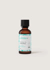 Ruskea lasipullo mustalla muovisella kierrekorkilla, pystyssä; pullossa mattavalkoinen suorakulmainen etiketti turkoosein kuvitetuin lehtikuvioin; brändinimi ja tuotetieto "puhdas+ Essential Oil Eucalyptus" painettu selkeällä tekstausvapaalla fontilla; pinta sileä ja kiiltävä; tausta yksinkertainen ja vaalea ilman esineitä, ihmisiä tai käsiä kuvassa.