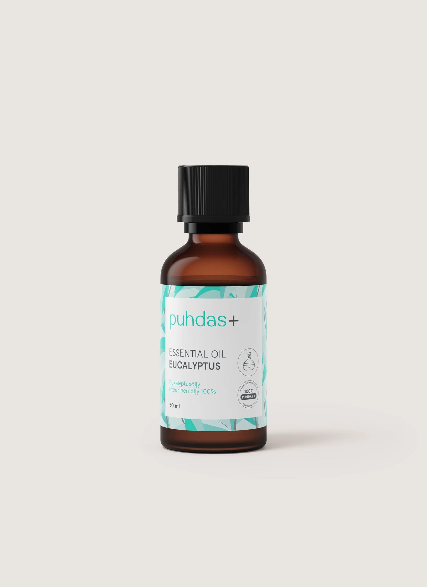 Ruskea lasipullo mustalla muovisella kierrekorkilla, pystyssä; pullossa mattavalkoinen suorakulmainen etiketti turkoosein kuvitetuin lehtikuvioin; brändinimi ja tuotetieto "puhdas+ Essential Oil Eucalyptus" painettu selkeällä tekstausvapaalla fontilla; pinta sileä ja kiiltävä; tausta yksinkertainen ja vaalea ilman esineitä, ihmisiä tai käsiä kuvassa.