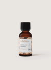 puhdas+ Essential Oil Cinnamon -pullo, pieni meripihkanvärinen lasipullo mattamustalla kierrekorkilla ja suorakulmaisella valkoisella etiketillä, pystyssä vaaleaa taustaa vasten; etiketissä lukee "puhdas+ Essential Oil Cinnamon" sekä englanniksi että suomeksi selkeällä tekstausvapaalla fontilla; ei ihmisiä tai toimintaa kuvassa.