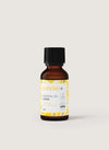 puhdas+ Essential Oil Lemon -pullo, pieni ruskea pullo mustalla korkilla, keltaisia lehtikuvioita ja tekstiä, joka ilmoittaa 100-prosenttisesti puhtaan sitruunaöljyn, 25 ml; pullo sylinterimäinen mattapinnalla ja kierrekorkilla; etikettityyli siistiä modernia tekstausvapaata mustaa ja keltaista tekstiä; tausta yksinkertainen ja vaalea, ei rekvisiittaa tai ihmisiä näkyvissä; kuva edestäpäin otettu tuotekuva.
