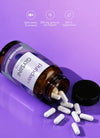 Puhdas+ Glysiini -pullo kyljellään violetilla taustalla, kapseleita valumassa ulos, yllä ikonit valmistusmaasta, annoksesta ja vegaanisuudesta