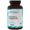 Puhdas+ Kalsium & Magnesium + K2-vitamiini + D3-vitamiini; ruskea muovipullo tekstillä ”puhdas+ Kalsium & Magnesium + K2 + D3”, valkoinen ja sininen mattaetiketti, lieriömäinen muoto kierrekorkilla; etiketissä suomenkielistä ravintolisätietoa, pyöreä ”100%”-laatumerkkikuvake ja modernia groteskityyppografiaa; tuote kuvattu tasaisella valkoisella taustalla ilman ihmisiä tai muita esineitä.