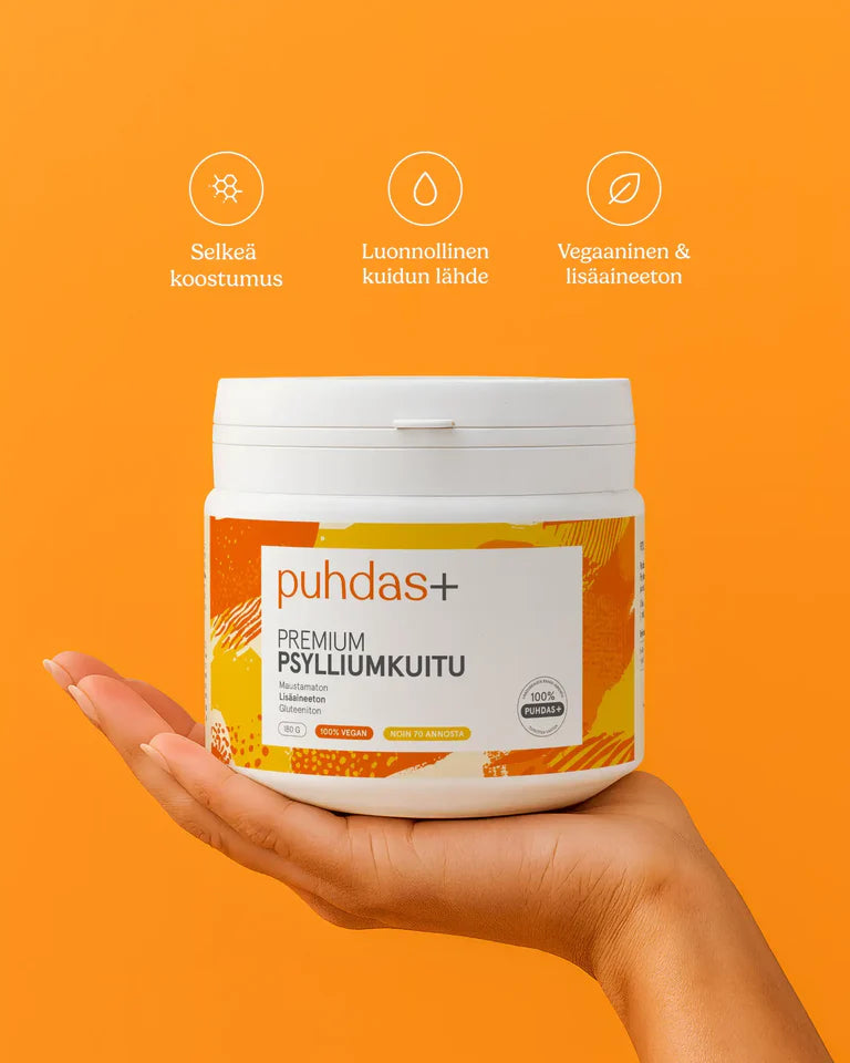 puhdas+ Premium Psylliumkuitu; käsi pitelee valkoista, lieriömäistä muovipurkkia mattapinnalla, etiketissä selkeää groteskitekstiä; pakkauksessa kuvakkeita ja suomenkielistä tekstiä puhtaasta koostumuksesta, luonnollisesta psylliumkuidusta, vegaanisuudesta ja lisäaineettomuudesta; tausta yhtenäisen oranssi; lähikuva tuotteesta.