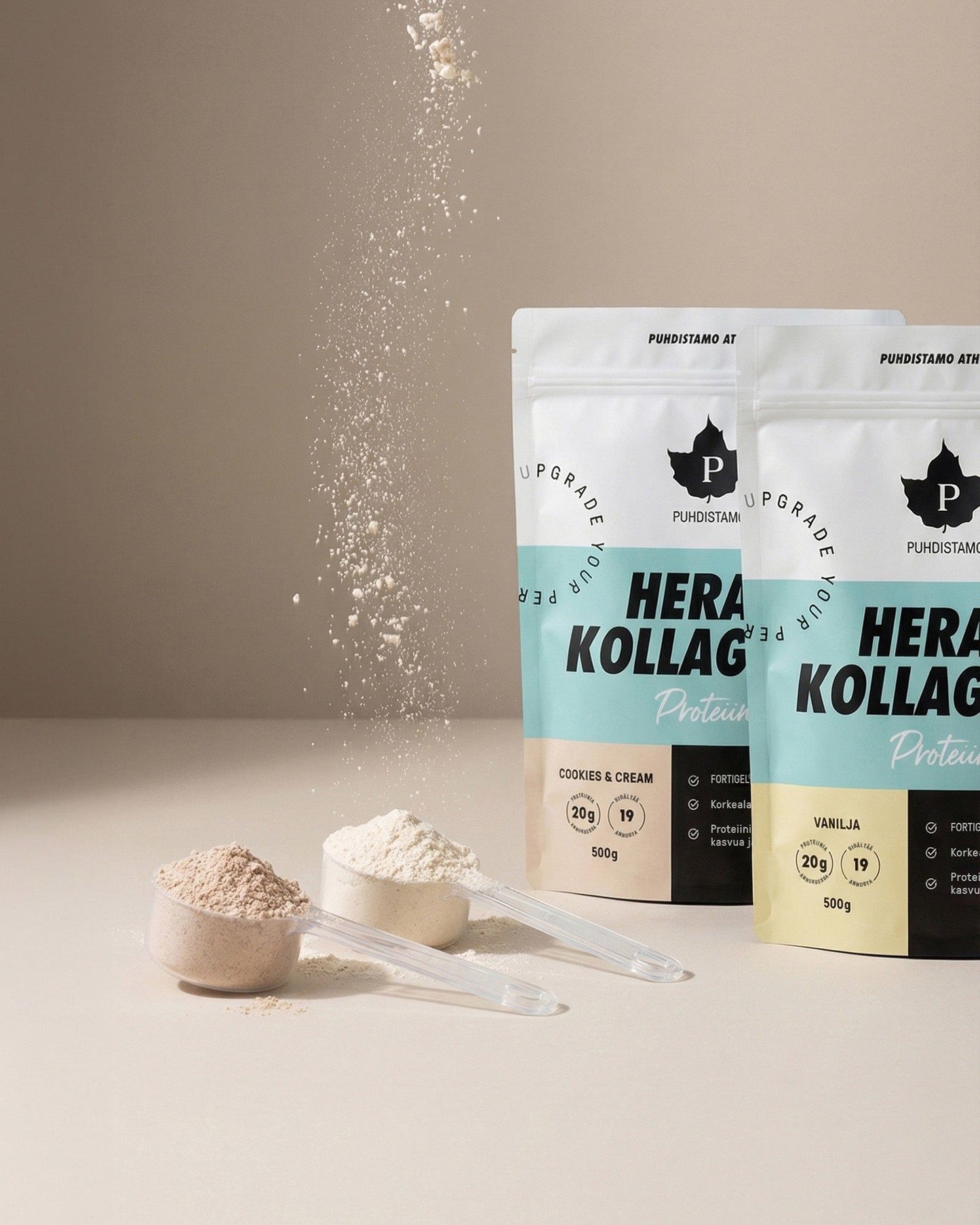 Puhdistamo Hera & Kollageeni Vanilja; kaksi Puhdistamo Herakollagen-proteiinijauhepussia, toinen vanilja- ja toinen cookies & cream -makuinen, edessä jauhetta täynnä olevat mittalusikat; kollageenipöly valuu yläreunasta alaosaan kuvassa; matat pussit uudelleensuljettavalla yläreunalla, tuotenimi ja maku lihavoidulla groteskilla; pussit pystyssä neutraalilla sileällä pinnalla, ei ihmisiä tai käsiä kuvassa.
