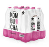 A 12-pack of pink raspberry kombucha bottles wrapped in matte white packaging. The surface shows large, bold black KOMBUCHA text and a detailed raspberry graphic in bright red. VADELMA is printed at the bottom. The package shape is rectangular with sharp edges. No people or background details are visible; product only, straight-on shot.