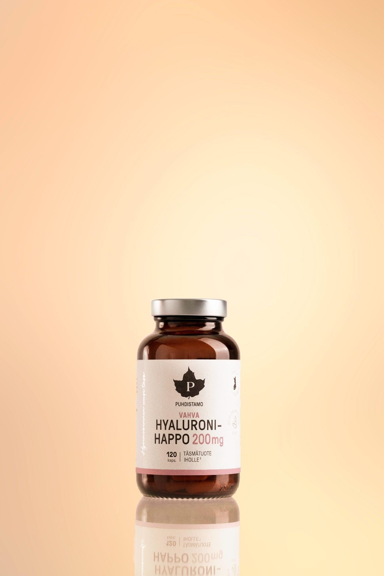 Puhdistamo Vahva Hyaluronihappo; ruskea lasipullo tekstillä Hyaluroni-Happo 200mg seisoo heijastavalla pinnalla persikanvärisen liukuvärin taustaa vasten; pullo lieriömäinen kiiltäväpinnalla, suljettu tummalla korkilla; etiketissä lihavoitua groteskitekstiä annostuksesta ja brändinimestä; pullo sisältää 120 kapselia hyaluronihappoa Puhdistamo-merkiltä.