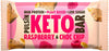 Pulsin KETO Proteiinipatukka Vadelma & Suklaahippu; Pulsin Keto Bar -kääre, vadelma- ja suklaahippumaku; vaaleanpunainen mattapintainen muovipakkaus painetuin kuvin vadelmista, suklaahiutaleista ja itse patukasta; lihavoitu groteskikirjasin näyttää tuotenimen ja avainlausekkeet: runsaasti proteiinia, kasviperäisiä ainesosia, vähän sokeria; ei ihmisiä tai rekvisiittaa; tausta tasainen ja neutraali, kuva suoraan edestä.