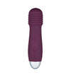 A purple handheld body massager with a ribbed top section, smooth cylindrical body, single round power button, and metallic silver base. The finish appears glossy on the colored areas and reflective on the metal part. No visible packaging or label text. The product is isolated against a plain white background in a studio shot.