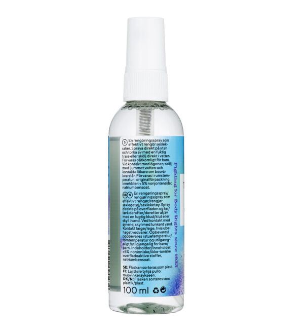 A clear 100 ml cylindrical spray bottle with a white plastic cap; glossy finish on both bottle and cap. Blue label wraps around lower half, matte surface, dense layout in sans-serif font. Symbols for recyclability and usage instructions present. Multilingual text occupies most of the label area. Isolated on a plain, light background with neutral lighting. A clear 100 ml spray bottle with a white cap, featuring a blue, multilingual label. The label includes usage instructions, symbols indicating