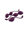 Three purple silicone kegel exercise balls of varying sizes, each with a matching silicone retrieval loop. All three have a smooth matte finish. Shapes are spherical with slender attached loops; no visible typography or packaging in the frame. The items are positioned parallel in a row on a plain white background, studio overhead shot, no people or hands visible.