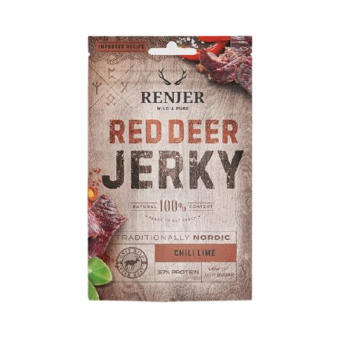 Renjer Nordic kuivattu saksanhirvi chili-lime; suorakulmainen, mattapintainen pussi yläsaumasululla ja rustiikkisella puukuvioinnilla; kuvituksena kuivattua lihaa, yrttejä ja chiliä; merkinnät 57 % proteiinia ja vähän sokeria.