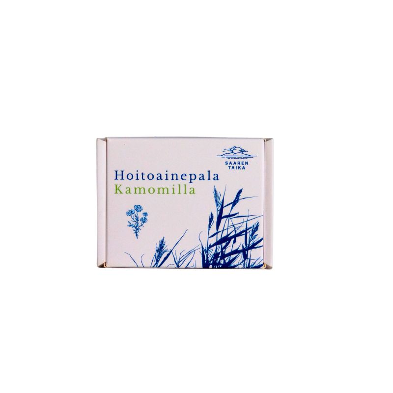 A white box with blue botanical illustrations and text that reads Hoitoainepala Kamomilla and Saaren Taika, featuring a touch of chamomile. The box is rectangular with matte finish, shows no visible contents, and rests on a plain background. Font is clear sans-serif in two sizes; all text is centered on the front panel. No people or hands are present in the image.