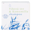 A white box with blue and green text reading Vihreä tee & Kamomilla shampoo features blue illustrations of grass and the Saaren Taika logo on the packaging. The box is rectangular with a matte finish. Product name uses bold sans-serif fonts in multiple colors. Packaging is shown against a plain, light background in a straight-on shot. No people or hands are present.