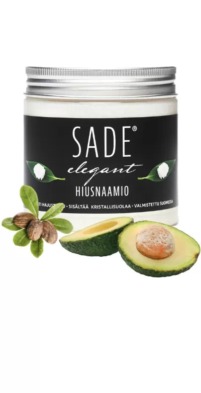 Sade Hiusnaamio; purkki SADE Elegant Hair Mask -hiusnaamiolle ravitsevine shea-pähkinöineen ja avokadopuolikkaan kera musta-valkoisen etiketin edessä, jossa vihreitä lehtikuvioita; astia lieriön muotoinen kiiltäväpintaisella mustalla kannella; etiketti modernia lihavoitua sans-serif-typografiaa valkoisena mustaa taustaa vasten, korostettuna vihreillä kuvitetuilla lehdillä; valkoinen tausta, lähikuva keskittyy tuotteeseen.