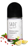 Sade Mineraalisuoladeodorantti Roll-On Granaattiomena-Sitruuna; SADE crystal -mineraalisuoladeodoranttipullo aseteltuna granaattiomenan siementen, sitruunaviipaleiden ja valkoisen kukan kera juurellaan; pullo kirkas ja lieriön muotoinen mattavalkoisella korkilla, etiketissä "SADE" lihavoidulla sans-serif-fontilla; valkoinen tausta, suoraan kuvattu; ei ihmisiä tai käsiä.