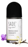Sade Mineraalisuoladeodorantti Roll-On Iris & Vanilja; kirkas roll-on-deodoranttipullo valkoisella korkilla, etiketissä teksti "SADE crystal Mineraalisuola-Deodorantti Iris & Vanilja" yksinkertaisella sans-serif-typografialla; pakkauksessa painettuja kukkakuvituksia ja vaniljapalko sekä oikeita violetteja ja valkoisia kukkia vieressä; tausta valkoinen; ei ihmisiä tai käsiä; pinta kiiltäväpintainen.