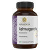 A brown plastic bottle labeled SAHAROGYA Ashwagandha with 60 vegan capsules, featuring ashwagandha for stress management. The cylindrical bottle has a matte finish and a screw cap. The label shows a purple decorative design on one side and text in multiple languages, printed in straightforward, sans-serif fonts. Product set against plain background; no people or props present.