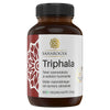 A brown plastic bottle labeled Triphala by Saharogya, containing 60 vegan capsules. The packaging is cylindrical with a white cap and has a glossy finish. The label displays Finnish and Swedish text in clear sans-serif font, along with a geometric Ayurvedic motif in red and white. The image is shot against a plain background with no people or extra objects visible.