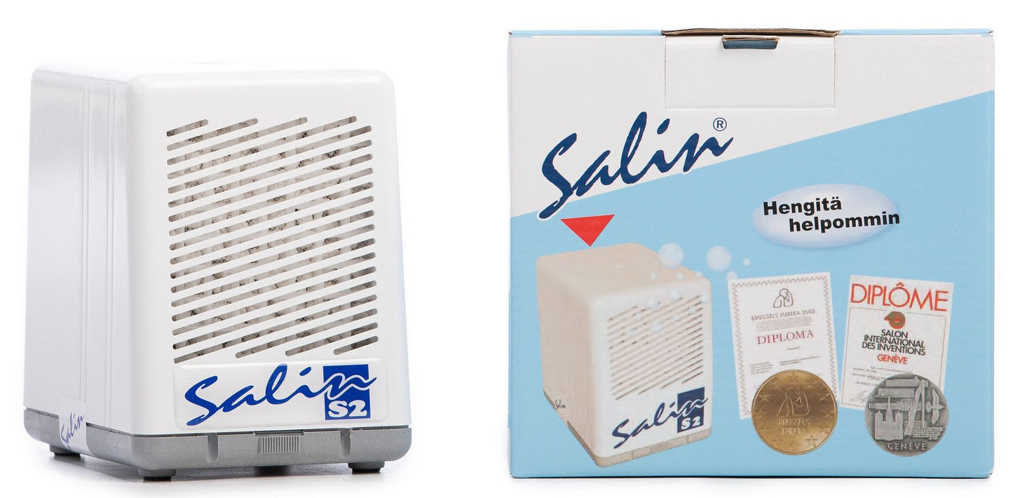 A white Salin S2 air purifier is shown next to its blue and white product box, which displays the device, awards, keywords, and the words Salin and Hengitä helpommin. The air purifier has a matte finish with a rectangular shape and curved grille openings on the front. The box features clear images of the device and printed graphics with sans-serif fonts. The setting is neutral with no people present.