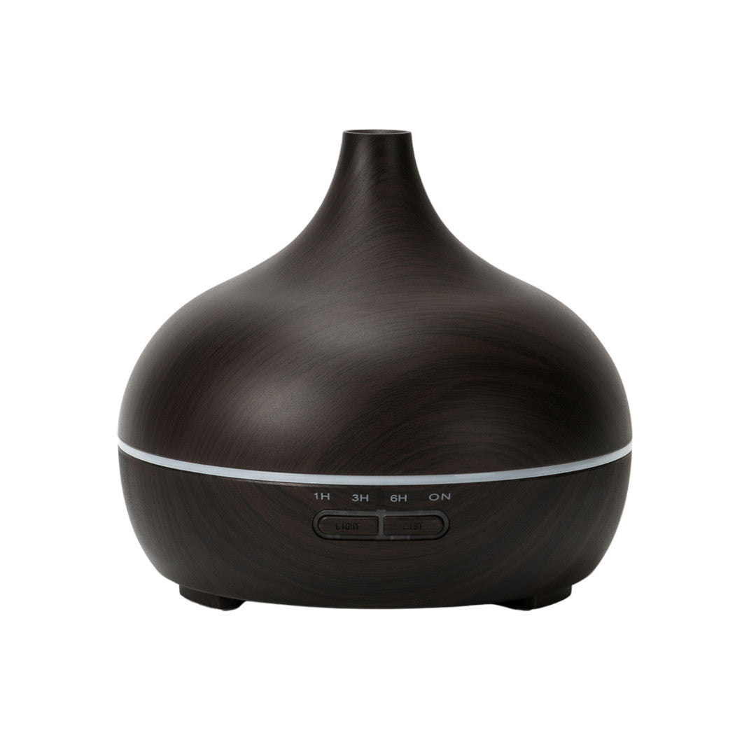 Salt Aroom Suola-Aroma Diffuuseri Aava; tumma, puukuvioitu ultraäänidiffuusori pyöreällä muodolla, kapealla höyryaukolla ja säätimillä 1H, 3H, 6H ja ON etupuolella; pinta on mattapintainen, siinä näkyviä vaakasuoria syykuvioita; säätimet ovat pinnan tasoiset pienellä groteskitekstillä; ei ihmisiä tai pakkausta näkyvissä; tuote keskellä valkoista taustaa.