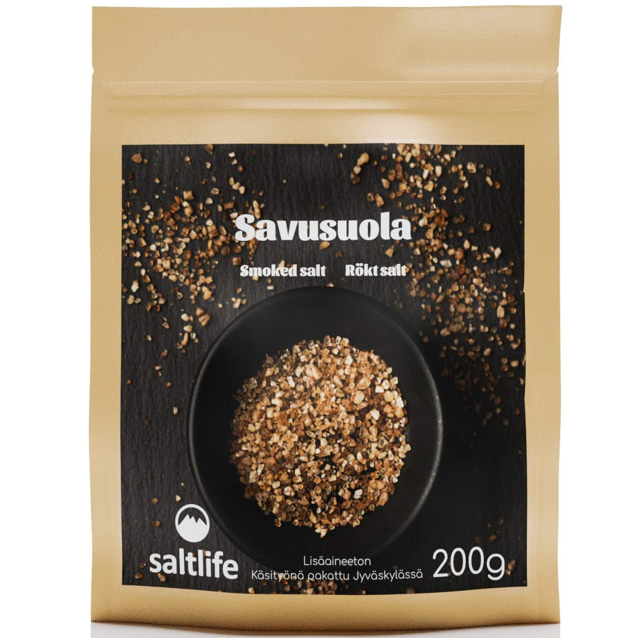 Saltlife Savusuola; beige suorakaiteen muotoinen pakkaus sisältää savustettua suolaa; pinta mattapintainen; etuosassa valokuva valkoisesta kulhosta täynnä karkeaa ruskeaa suolaa, muutama jyvänen hajallaan vieressä; huomiotekstissä Savusuola, 200g ja saltlife-logo selkeällä groteskifontilla; ei ihmisiä tai toimintaa; tuote kuvattu neutraalilla taustalla.