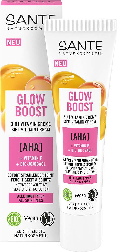 Sante Glow Boost 3 in 1 Vitamiinivoide; tuubi ja laatikko AHA-hapolla, F-vitamiinilla ja luomu-jojobaöljyllä rikastettua 3-in-1-vitamiinivoidetta; molemmat pakkaukset ovat suorakulmaisia; tuubi on mattapintainen, pääosin valkoinen keltaisin korostein; etiketit ilmoittavat sopivuuden kaikille ihotyypeille, vegaanisuuden, sertifioidun luomulaadun ja luomu-ainesosat; groteskikirjasinta pakkauksissa; tausta neutraali, ei ihmisiä tai käsiä näkyvissä.