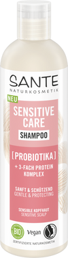 Sante Sensitive Care Shampoo; pullo probioottishampoota; sylinterinmuotoinen muovipakkaus, valkoinen vaaleanpunaisella etikettiosuudella; etiketissä siistiä groteskikirjasinta, tuotenimi lihavoituna; etuosassa selkeästi mainitaan "vegaaninen", "luomu" ja "probiootit" sekä sopivuus herkälle hiuspohjalle; pinta mattapintainen; ei ihmisiä tai rekvisiittaa, kuvattu yksivärisellä taustalla.