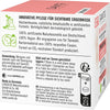 Sante Skin Protection 24h Kosteusvoide; valko-vaaleanpunainen Sante-kosmetiikkalaatikko saksankielisin tekstein, jotka kuvaavat luonnollisia ainesosia, ympäristöystävällistä pakkausta, käyttöohjeita ja säilytysneuvoja sekä vegaanikuvakkeen; luomusertifiointilogot ja yritysbrändäys sivussa; laatikko on suorakulmainen mattapinnalla musta-vaaleanpunaisin groteskitypografioin; tausta on neutraali pinta; ei ihmisiä tai käsiä näkyvissä.