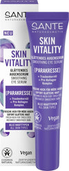 Sante Skin Vitality Silmäseerumi; tuubi ja laatikko tasoittavaa silmänympärysseerumia violetein korostein, tekstiä vegaanisesta kaavasta ja sopivuudesta kaikille ihotyypeille; molemmissa vegaani- ja Cosmos Natural -sertifiointilogot; tuubin pinta on pehmeän mattapintainen, laatikko suorakulmainen mattapinnalla; groteskikirjasintyylit mustana ja violettina molemmissa esineissä; tausta puhtaan valkoinen, tuote keskitettynä, ei ihmisiä tai käsiä näkyvissä.