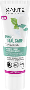 Sante Total Care Hammastahna Minttu; tuubi Sante Naturkosmetik Minze Total Care -hammastahnaa raikkain minttulehtikuvituksin ja tuotetiedoin saksaksi valkoisella taustalla; tuubi pääosin valkoinen sinisin ja vihrein korostuksin, selkeä groteskikirjasin ja mattapinta; korkki valkoista muovia; kuva otettu suoraan edestä, ei ihmisiä tai käsiä.