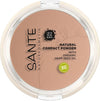 Sante Kivipuuteri; pyöreä Sante Natural Compact Powder -rasia luomu-hamppusiemenöljyllä beigen sävyssä; pyöreä läpinäkyväkantinen muovirasia sisällä mattapuuteria; kannessa painettu tuotenimi groteskikirjasimella ja vihreä Bio-sertifiointimerkki; ei ihmisiä tai käsiä; tausta tasainen, kuva otettu suoraan ylhäältä.