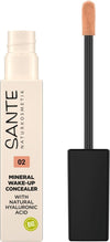 Sante Nestemäinen Peitevoide; tuubi Sante Mineral Wake-Up Concealer -peitevoidetta hipiäsivellinapplikaattorilla, merkitty sävyllä 02 ja rikastettu luonnollisella hyaluronihapolla; pakkaus vaaleanbeige kiiltävän mustan korkin kera, vihreä BIO-symboli näkyvissä; etikettitekstissä tuotenimi ja koostumustiedot groteskikirjasimella; ei ihmisiä tai käsiä; tausta valkoinen studioasetelma.