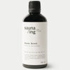 sauna/ing Sauna Scent Pine & Lavender; musta mattapintainen pullo tekstillä Sauna Scent, tuoksu mänty ja laventeli, sisältö 100 ml; pullo lieriömäinen, muovia tai lasia; etiketissä ainesosia ja koordinaatteja minimalistisen musta-valkoisen väriteeman mukaisesti selkeällä groteskityypografialla; ei ihmisiä tai käsiä; yhtenäinen neutraali tausta, studiotuotekuva.