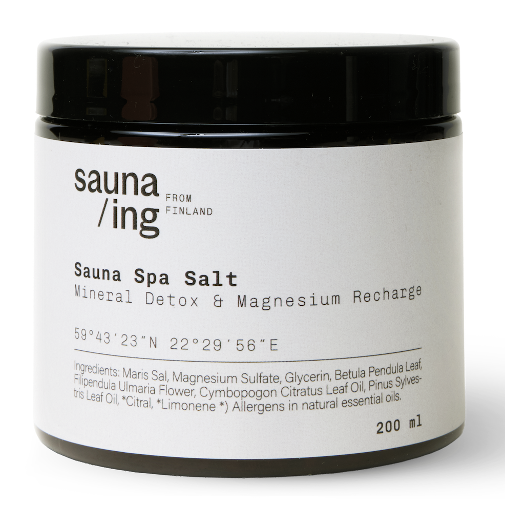 sauna/ing Sauna Spa Salt; musta lieriömäinen purkki mattapinnalla tekstillä Sauna Spa Salt; etiketissä ainesosaluettelo sekä avainsanat Mineral Detox & Magnesium Recharge; tuotteen alkuperä Suomi ja koko 200 ml mainittu; valkoista groteskitekstiä tummaa taustaa vasten; studiokuva, neutraali tausta, ei ihmisiä tai käsiä.