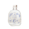 SEES x Moomin Room Diffuser Nordic Summer; kirkas lasipullo puisella korkilla, tekstillä MOOMIN SEES SCENT DIFFUSER Nordic Summer isoin groteskikirjaimin; pullo lieriömäinen kiiltäväpinnalla, sinistä viivataidetta kukista, linnuista ja muumihahmosta etuosassa; läpinäkyvä neste näkyvissä sisällä; tuote kuvattu vaalealla taustalla, ei ihmisiä tai käsiä.